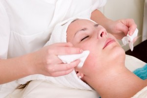 Lotion being wiped off during a facial at a beauty spa.